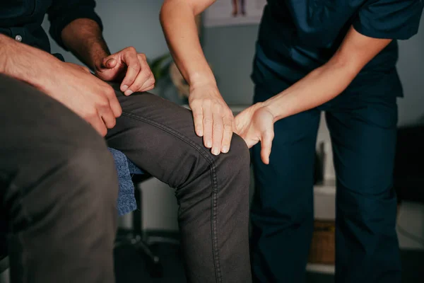 Κοντινό πλάνο γυναίκα φυσιοθεραπευτής βοηθώντας ασθενή με τραυματισμένο γόνατο — Φωτογραφία Αρχείου
