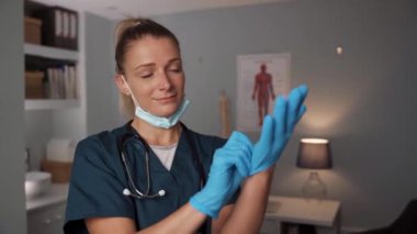 Beyaz kadın hemşire cerrahi eldiven takıyor.