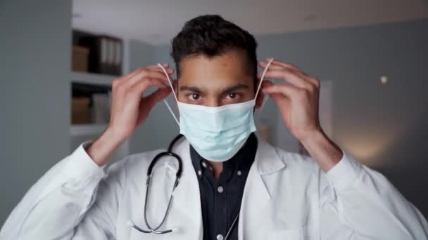 Misto raça masculino médico em pé no escritório vestindo cirúrgico máscara — Vídeo de Stock