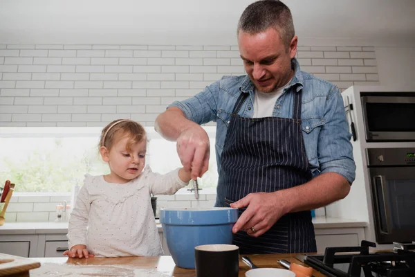 Pai e filha assar na cozinha, juntamente com tigela de mistura — Fotografia de Stock