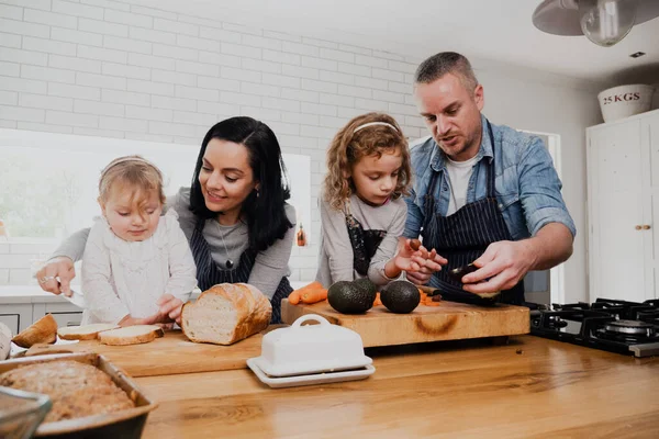 Jovens caucasianos família cozinhar juntos, irmãs e pais se divertindo — Fotografia de Stock