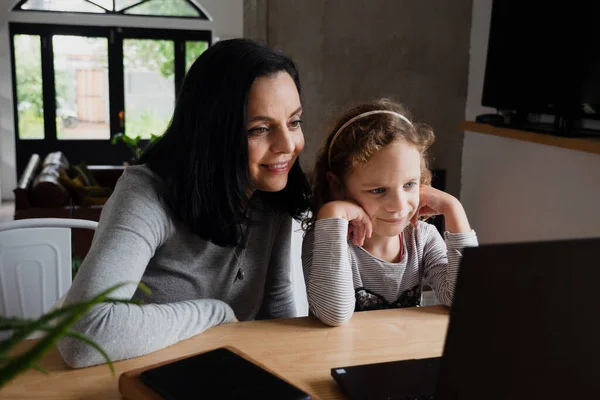 幸せなお母さんと子供の娘はラップトップを見て、笑顔のお母さんと子供の女の子持っています楽しいですオンラインビデオでコンピュータ — ストック写真
