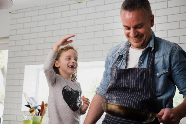 Pai e filha rindo juntos assando na cozinha. — Fotografia de Stock