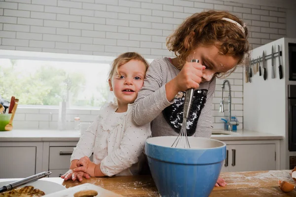 Dois irmãos sorridentes cozinhando juntos na cozinha. — Fotografia de Stock