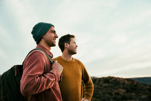 Two caucasian male friends on vacation walking in the wilderness embracing nature — Stock Photo, Image