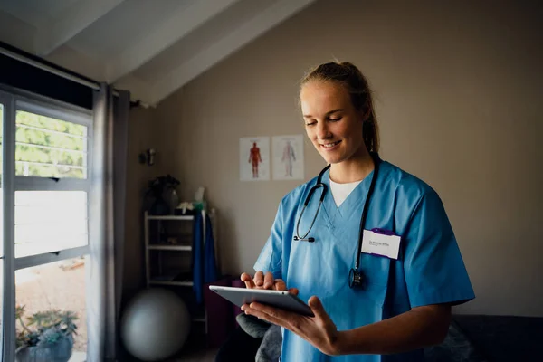 Infirmière caucasienne se préparant pour la consultation en ligne avec le patient sur appel vidéo debout dans la clinique — Photo