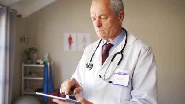 Caucásico médico masculino deslizando en tableta digital presentó los resultados de la prueba de paciente, de pie en la clínica. — Vídeos de Stock