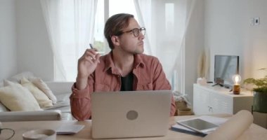 Beyaz erkek öğrenci evde çalışıyor. Laptop kullanarak sınavlara çalışıyor.