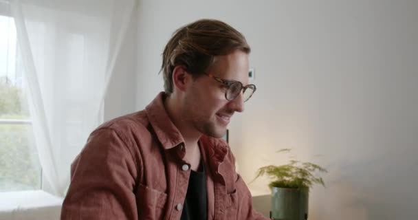 Caucásico estudiante masculino tomando gafas extrañas y sonriendo después de terminar la tarea de trabajo — Vídeo de stock