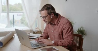 Video çağrısında sınıf arkadaşlarıyla sohbet ederken gülümseyen beyaz erkek öğrenci