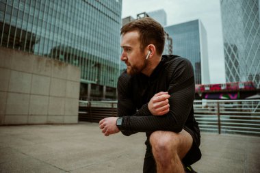 Kafkas erkek fitness antrenmanı. Hava podlarıyla müzik dinliyorlar. 