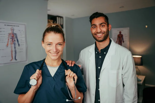 Blanke vrouwelijke verpleegster staande met gemengde ras mannelijke chirurg — Stockfoto