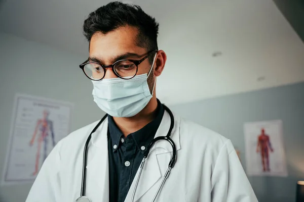 Mixte race homme médecin portant des lunettes de travail n clinique — Photo