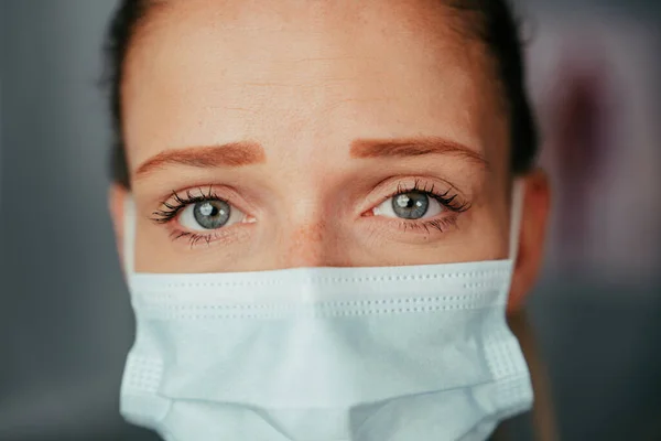 Beyaz kadın hemşire stajyer doktor ofisinde maske takıyor. — Stok fotoğraf