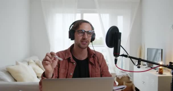 Podcast masculin caucasien enregistrement dans le salon en utilisant ordinateur portable et microphone — Video