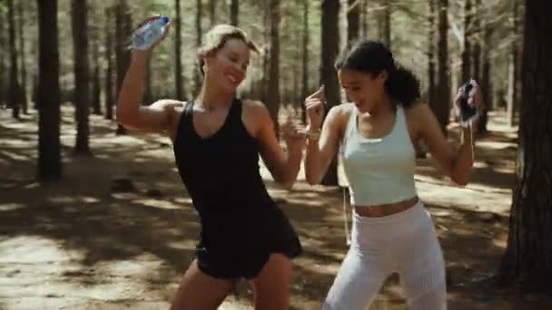 Друзья смешанной расы танцуют вместе в лесу — стоковое видео