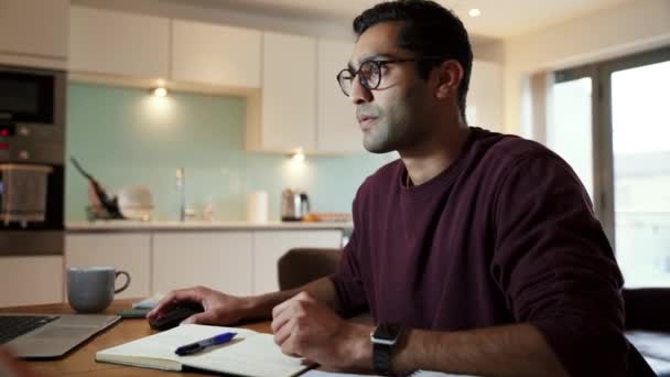 Деловой человек смешанной расы, работающий из дома, пьет кофе, печатая на ноутбуке, наслаждаясь домашним офисом — стоковое видео