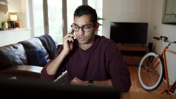 Homme d'affaires de race mixte parlant sur l'appareil cellulaire travaillant à partir du bureau à domicile — Video