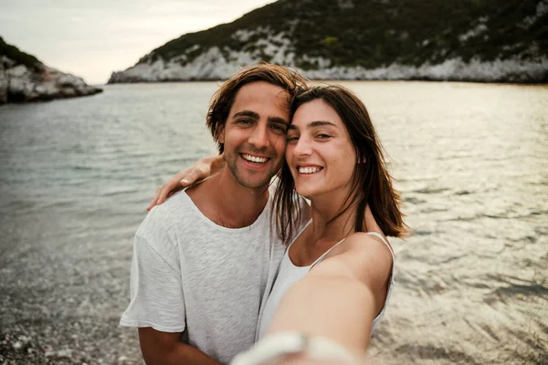 Blank paar glimlachen terwijl het nemen van selfie op het strand — Stockfoto