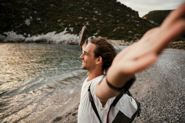 Caucasian male walking on the beach with arms wide open embracing the fresh air — Stock Photo, Image