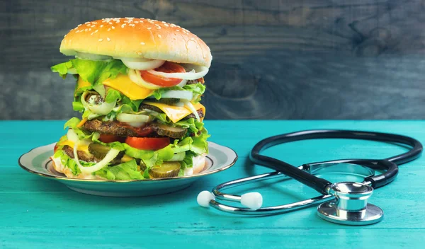 Big cheeseburger deluxe and stethoscope — 스톡 사진
