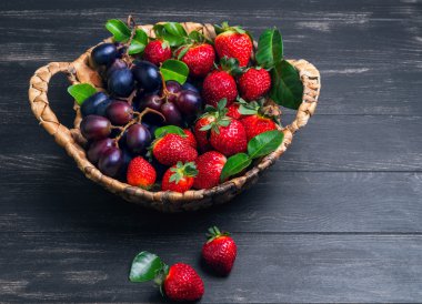 Wicker basket with grapes and strawberries