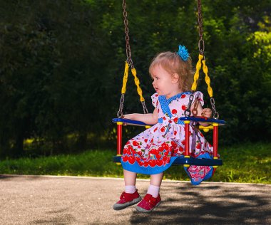 Küçük kız haddelenmiş bir salıncak parkta açma