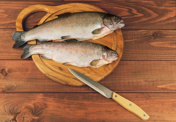 Trucha fresca de pescado crudo es dos piezas en el tablero —  Fotos de Stock