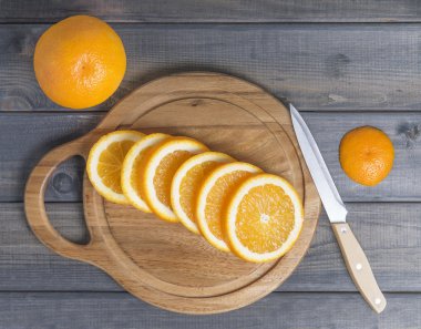 Kesme tahtası üzerinde turuncu dilimlenmiş.