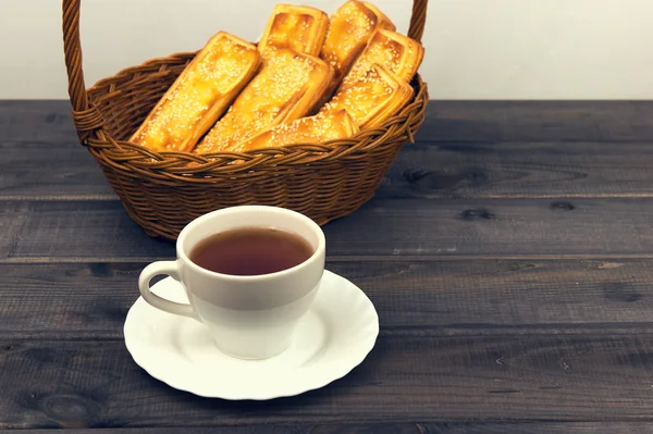 Korb mit Stockbrot, weißer Porzellantasse und Untertasse — Stockfoto