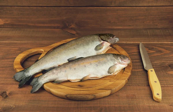 Trucha fresca de pescado crudo es dos piezas en el tablero — Foto de Stock