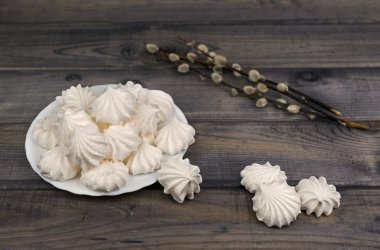 On the wooden table is a white porcelain plate with cakes and me