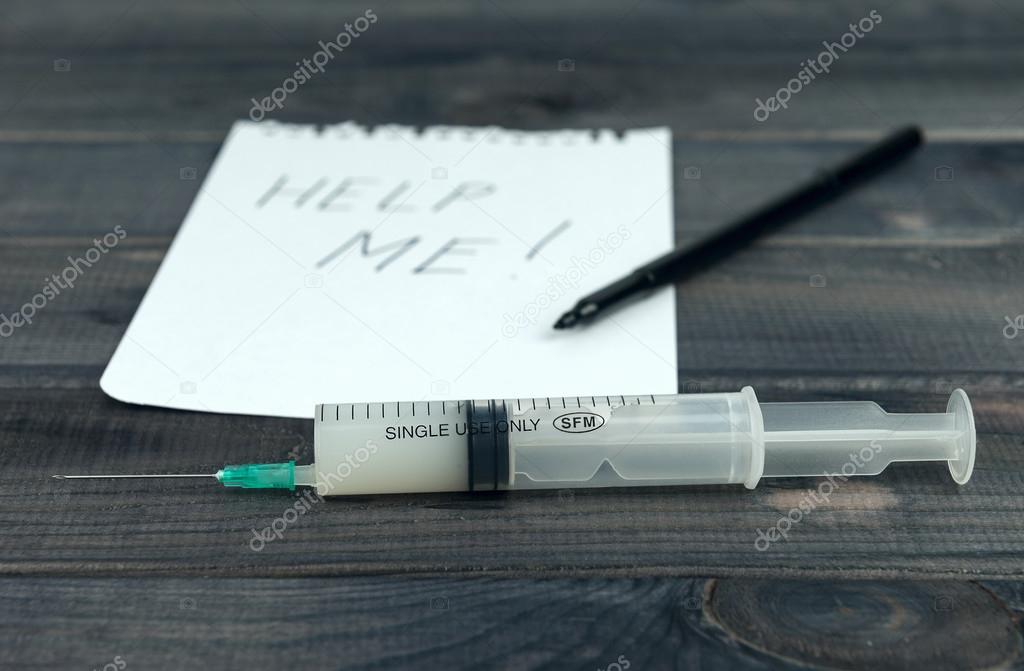 On the wooden table syringe with a drug