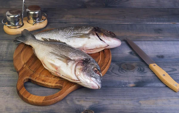 N 一张小木桌，切割板与新鲜原料多拉多鲺鱼 — 图库照片