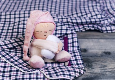 On wooden table checkered flannel pajamas and a sleeping soft 