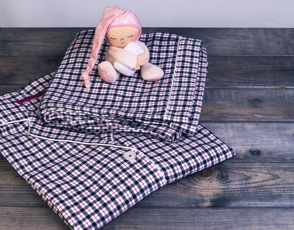 En la mesa de madera a cuadros pijama de franela y un sueño suave — Foto de Stock