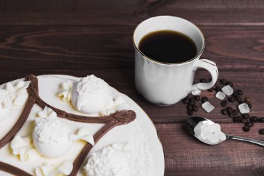 On a wooden table delicacy - saucer with piece of cake