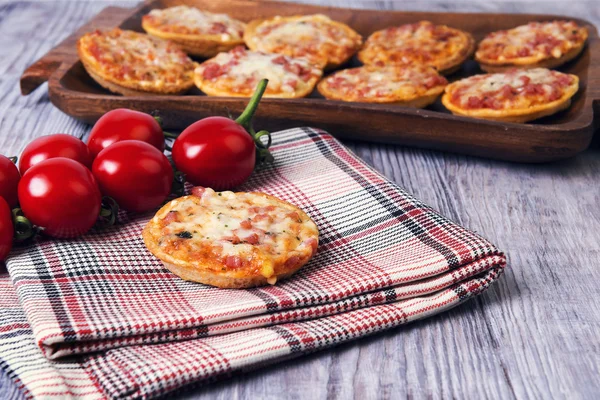 Mini pizzas em uma mesa de madeira — Fotografia de Stock