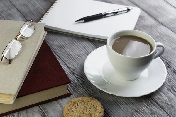 Dos libros, taza de café de porcelana blanca con leche y un platillo — Foto de Stock