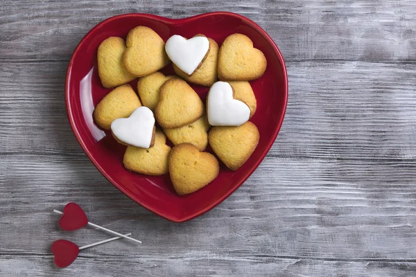 Placa roja con galletas en forma de corazón — Foto de Stock