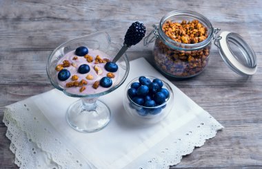 çilek ve granola yoğurt ile dekore edilmiş cam vazo