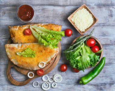Kapalı pizza calzone hafif ahşap arka plan üzerinde