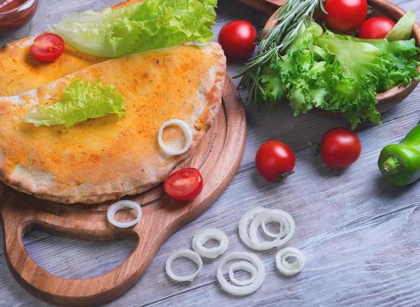 Zárt pizza calzone a világos fából készült háttér — Stock Fotó