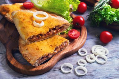 Kapalı pizza calzone hafif ahşap arka plan üzerinde