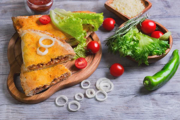 Gesloten pizza calzone op een lichte houten achtergrond — Stockfoto