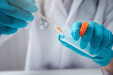 Doktor ya da tıbbi personel laboratuvarda muayene için hastadan salgılar topluyor. Salgın Koronavirüs, COVID-19.