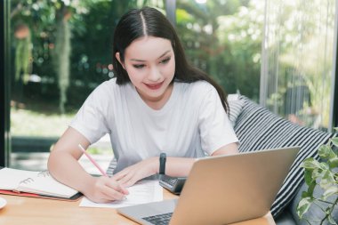 İnternetten ders izleyen ve evden ders çalışan genç bir öğrenci. Bilgisayarı kullanıyor ve internetten öğreniyor. Uzaklık öğrenimi çevrimiçi eğitim.