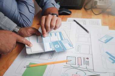 UX ya da UI tasarımcıları akıllı telefon uygulama düzeni prototip projeleri üzerinde tasarım yapıyorlar.