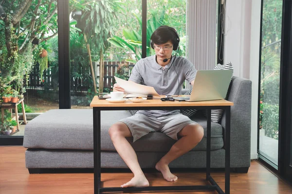 İş adamı video görüşmesi. Müşteriler ofisteki laptopta. Adam kulaklık takıyor ya da internetten eğitim alıyor..