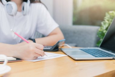 İnternetten ders izleyen ve evden ders çalışan genç bir öğrenci. Bilgisayarı kullanıyor ve internetten öğreniyor. Uzaklık öğrenimi çevrimiçi eğitim.